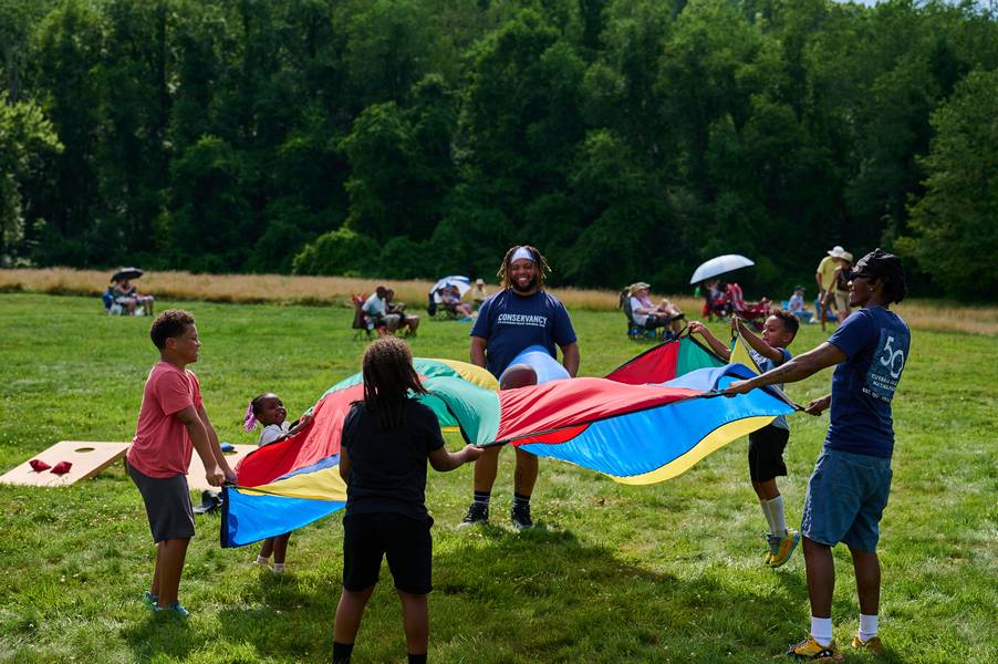 Kids enjoying parachute games at Rhythm on the River.